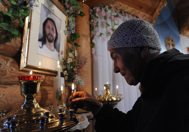 Una anciana colocando una vela como su señor salvador, AFP/Getty Images)